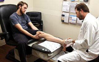 The Doctor is attending to a Patient with Sprained Ankle - OCfeet.com